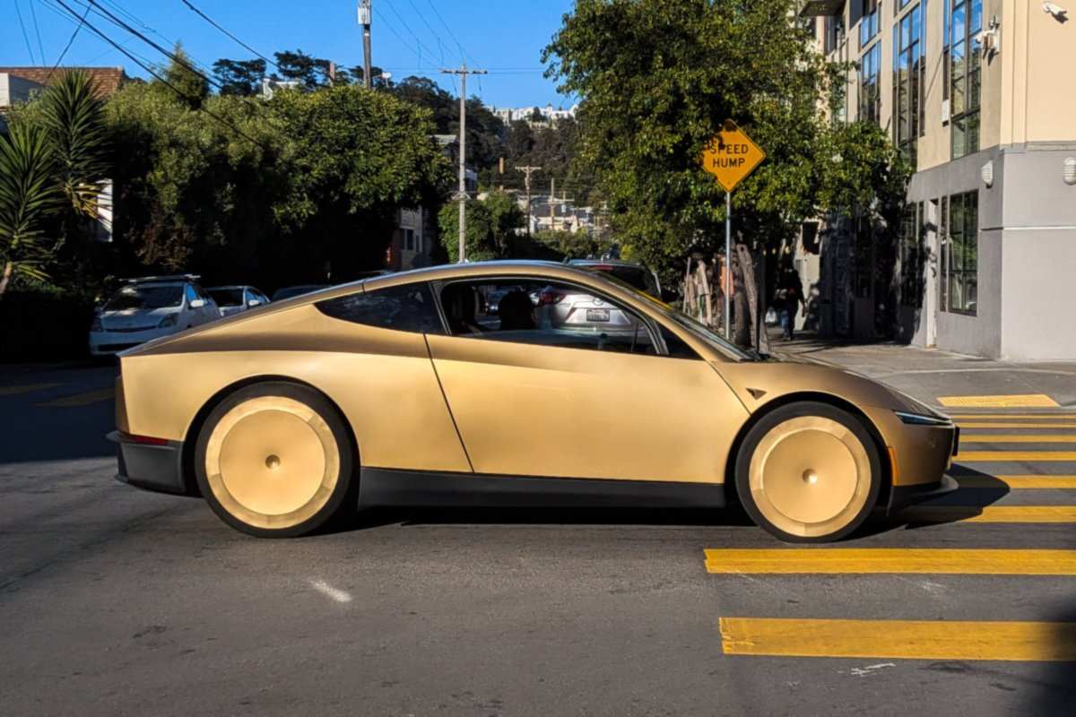 Gold Tesla Cybercab with no steering wheel driving down a street in San Francisco, June 2026