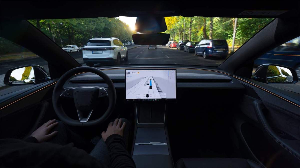 View from inside a Tesla, with the driver's hands near the wheel and the system visualisation on the centre screen