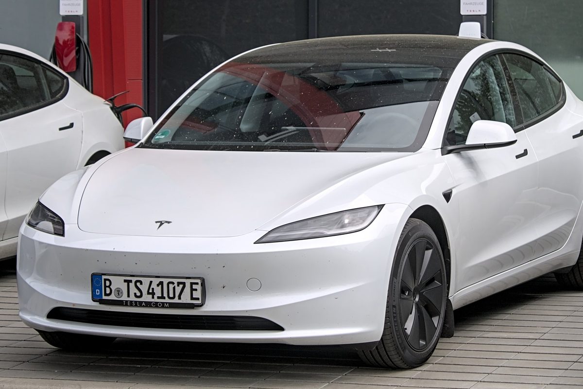 A white Tesla Model 3 Highland seen from the front, with its slim LED headlights, parked in Neu-Ulm, Germany
